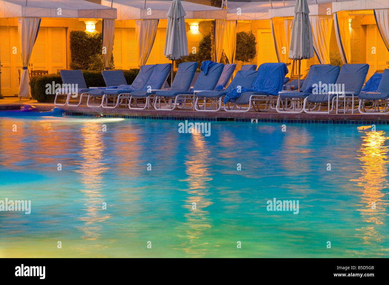 Resort Hotel Piscine avec des réflexions et une chaise lounges dans la soirée Banque D'Images Resort Hotel Piscine avec des réflexions et une chaise lounges dans la soirée Banque D'Images