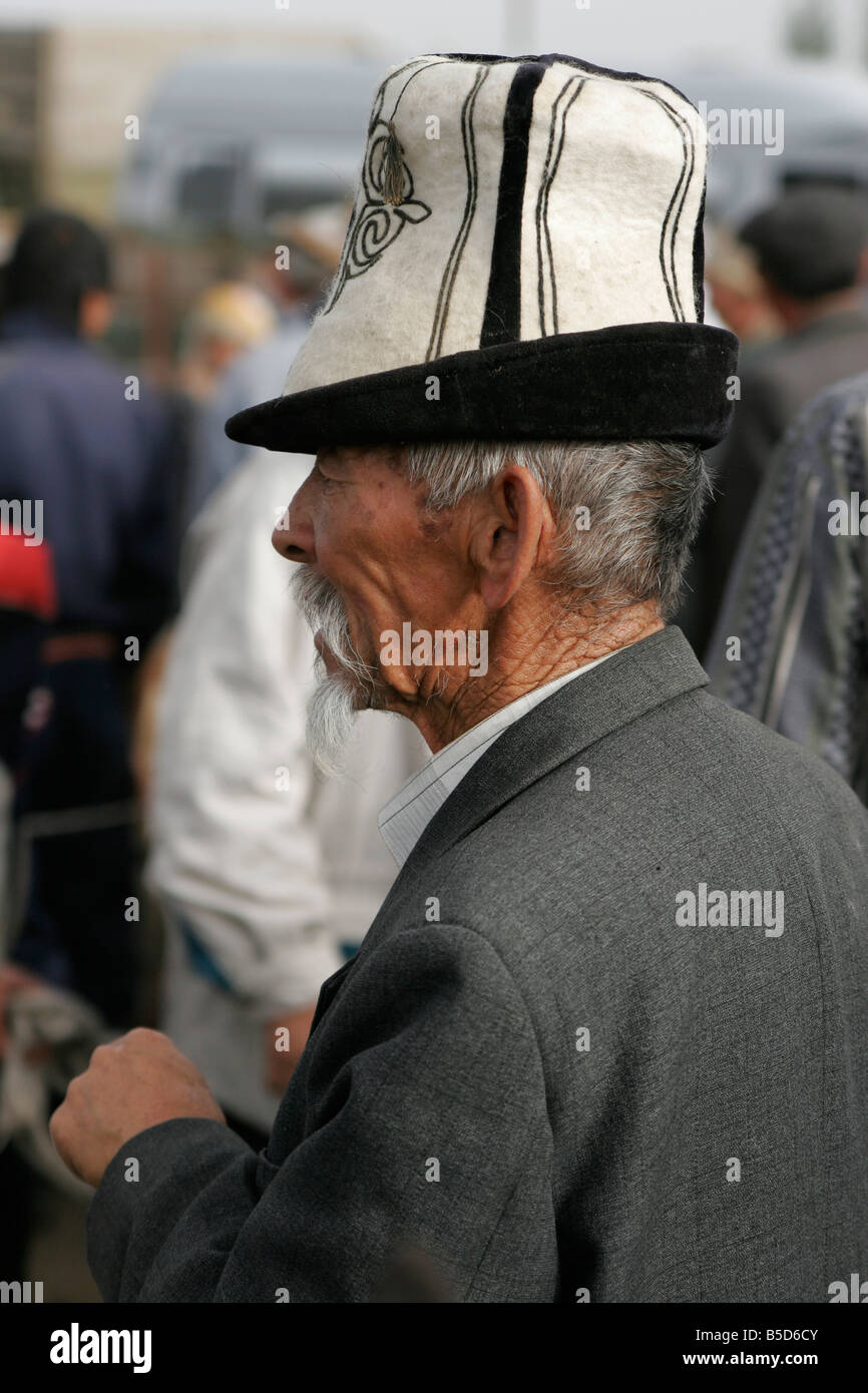 Portrait d'ancien homme portant chapeau traditionnel kirghize (kalpak) le dimanche marché des animaux à Karakol, le Kirghizistan, l'Asie centrale Banque D'Images