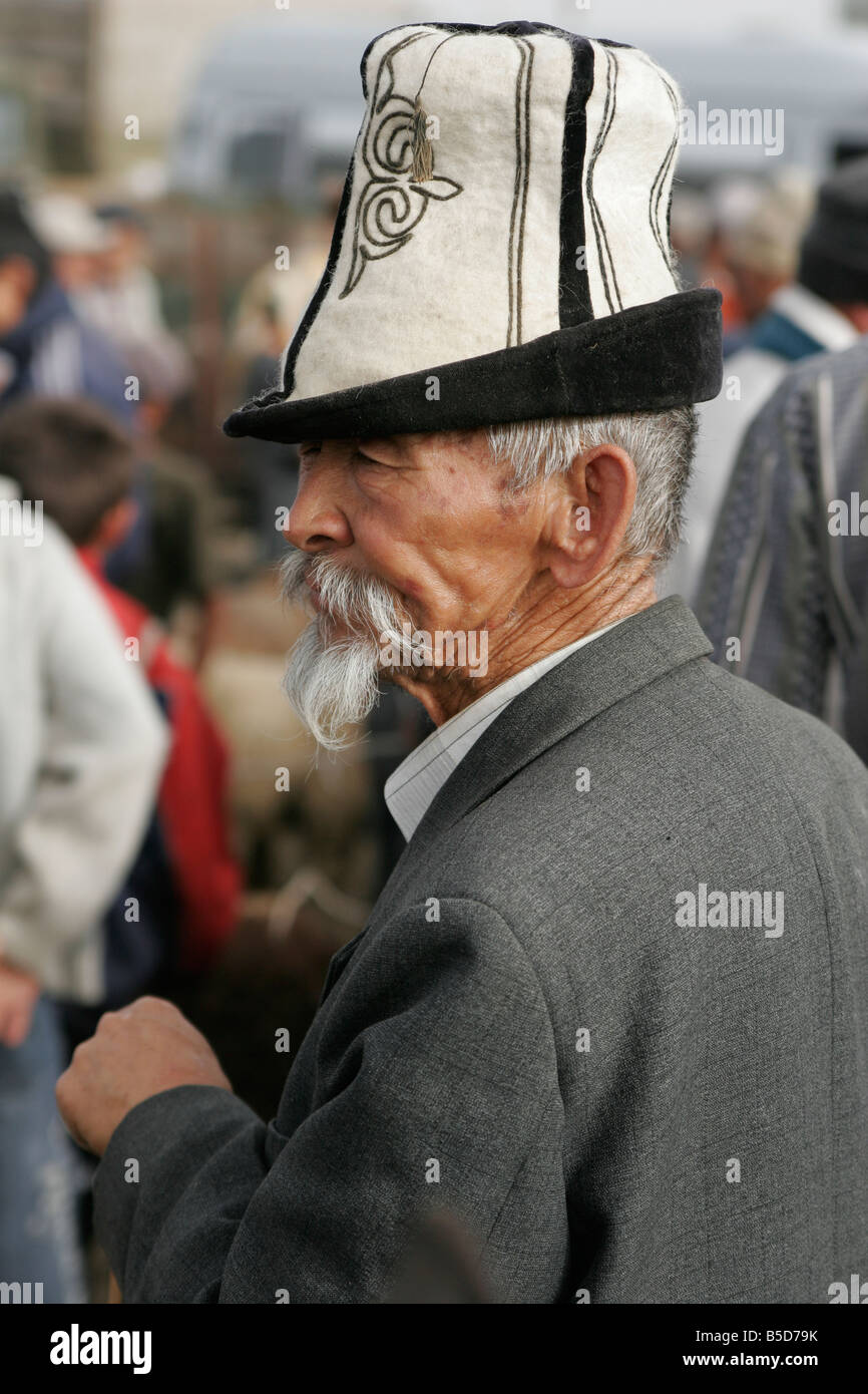 Portrait d'ancien homme portant chapeau traditionnel kirghize (kalpak) le dimanche marché des animaux à Karakol, le Kirghizistan, l'Asie centrale Banque D'Images