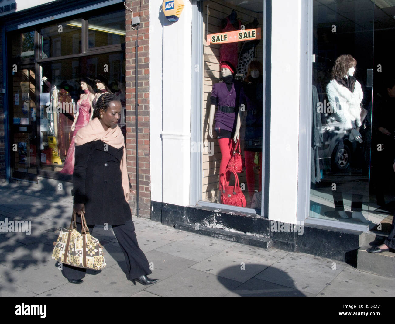 UK. Femme en passant devant une boutique de mode, de Fonthill Road, Londres Photo Julio Etchart Banque D'Images