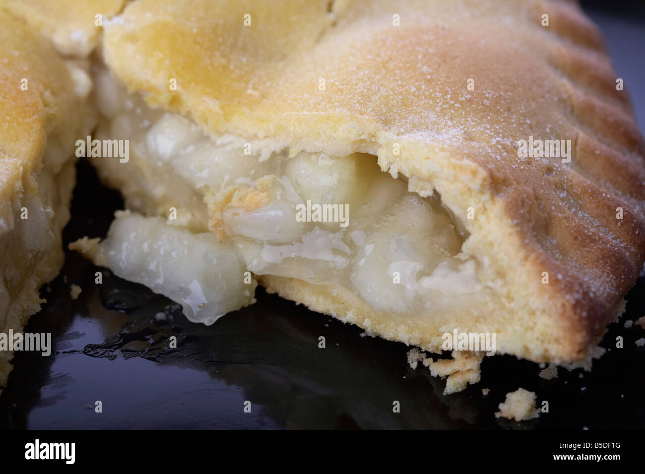 Close up of Irish bramley tarte gâteau avec tranche sur une plaque noire Banque D'Images