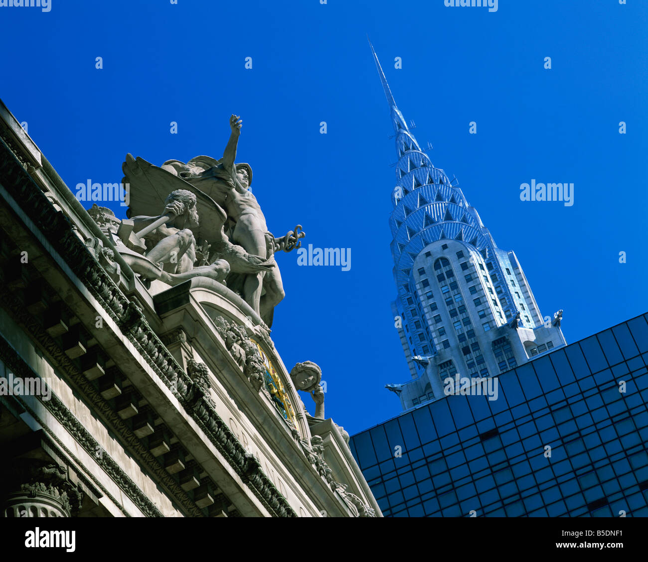 Statues sur haut de la gare Grand Central, avec le Chrysler Building à l'arrière-plan, à prendre le soir à New York, USA Banque D'Images