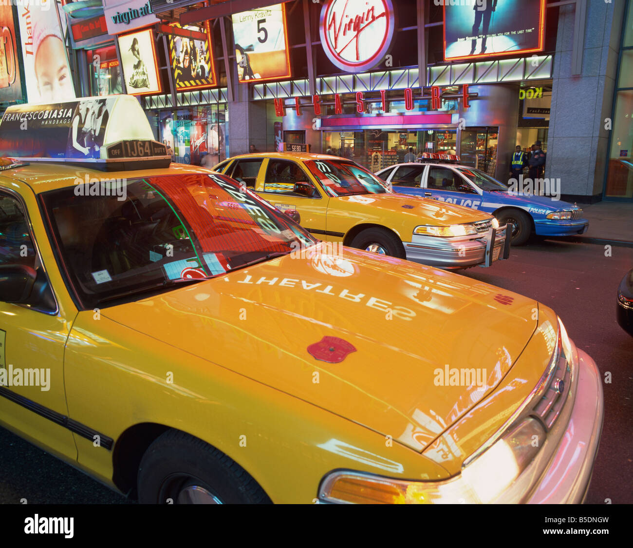 Les taxis jaunes sur la rue la nuit à Times Square, avec Virgin Megastore en arrière-plan, à New York, USA Banque D'Images
