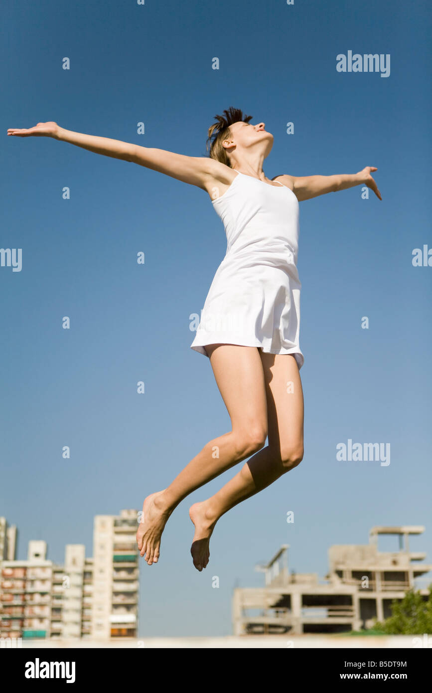 jeune fille sautant en l'air bras jambes en croix Stock Photo