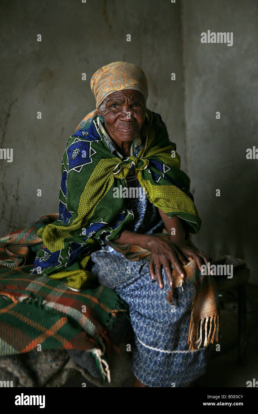 Grand-mère Swazi est assise dans sa maison construite par la Croix-Rouge, de Shiselweni, Swaziland, Afrique Banque D'Images