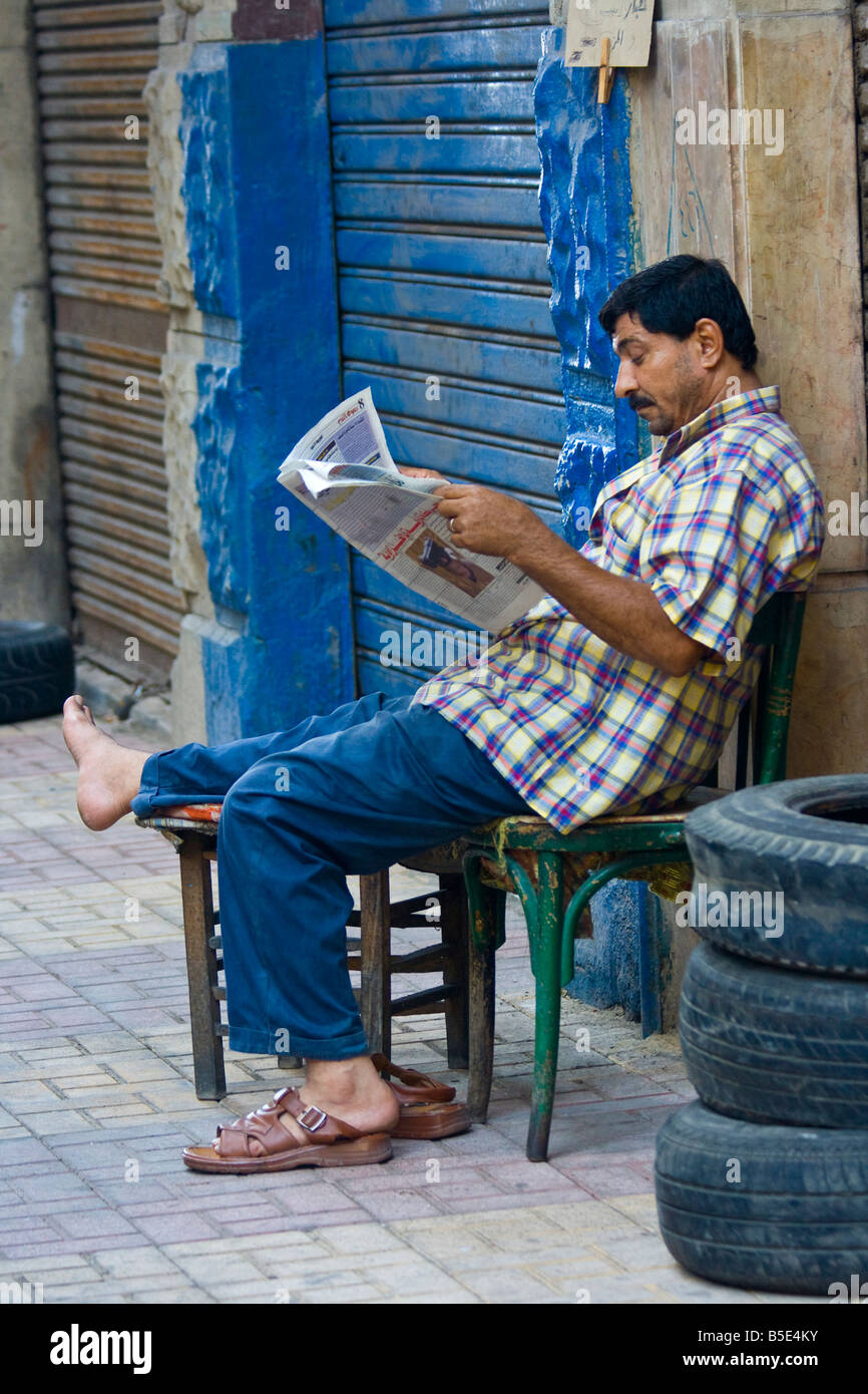 L'Homme égyptien lire un journal à Alexandria Egypte Banque D'Images