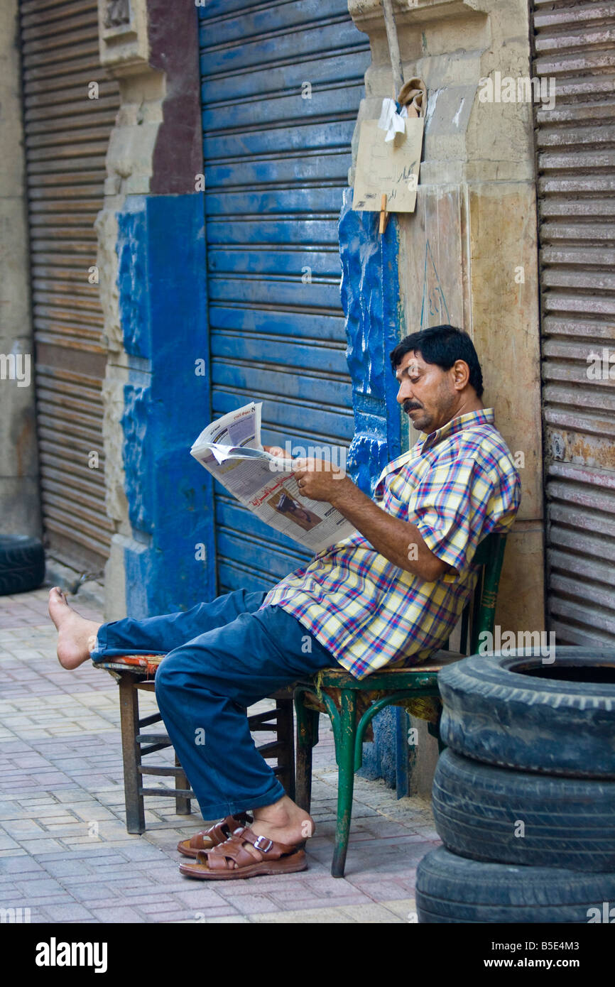 L'Homme égyptien lire un journal à Alexandria Egypte Banque D'Images