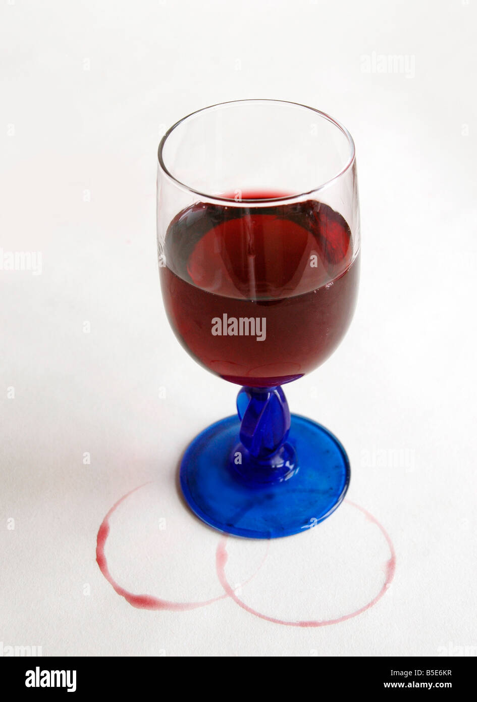 Un verre de vin avec des taches de vin de table blanc sur la propagation. Banque D'Images