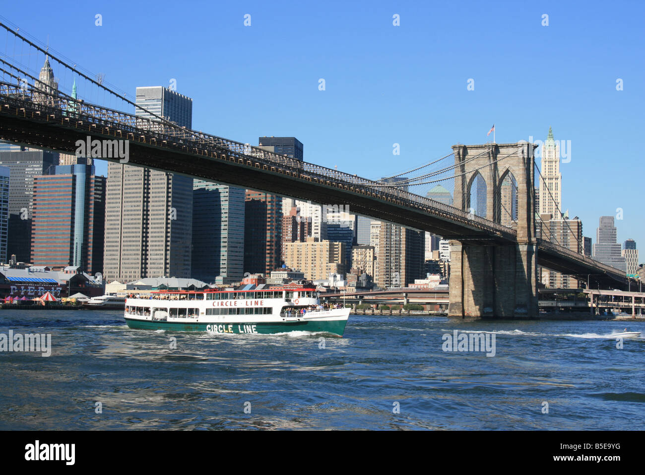 Bateau de croisière Circle Line passant sous le pont de Brooklyn. Banque D'Images