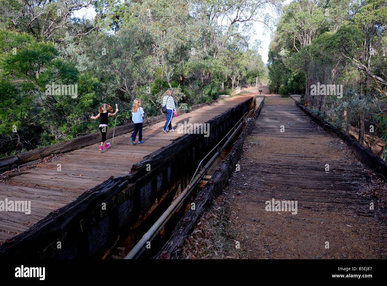 La mère et les deux filles marcher plus de bois abandonnés pont de chemin de fer. John Forrest National Park, Perth, Australie occidentale Banque D'Images