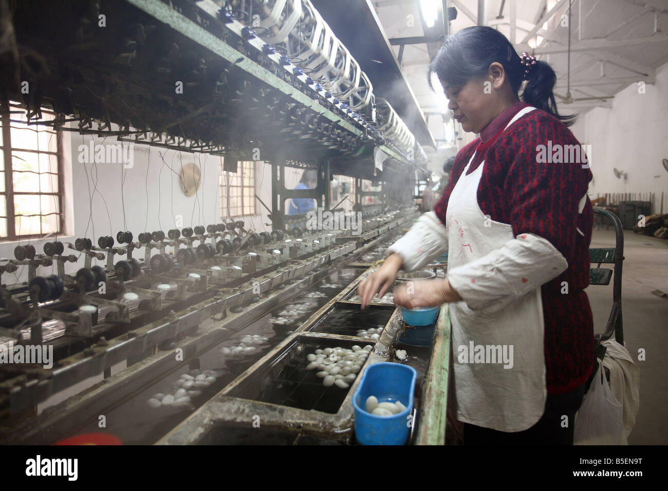 Une femme asiatique travaillant dans une usine de soie à Suzhou, Chine Banque D'Images