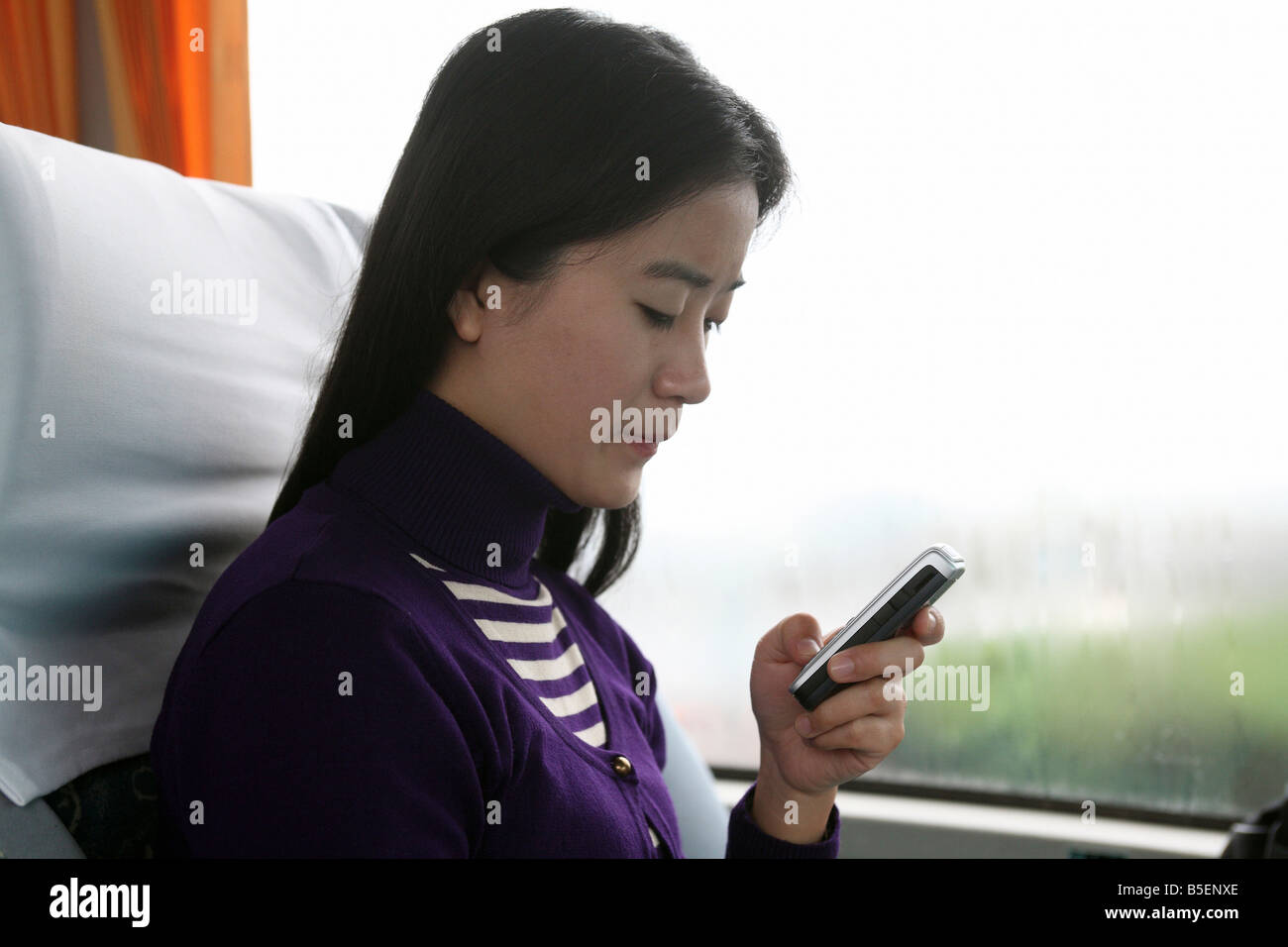 Une jeune femme asiatique l'écriture d'un sms, Shanghai, Chine Banque D'Images