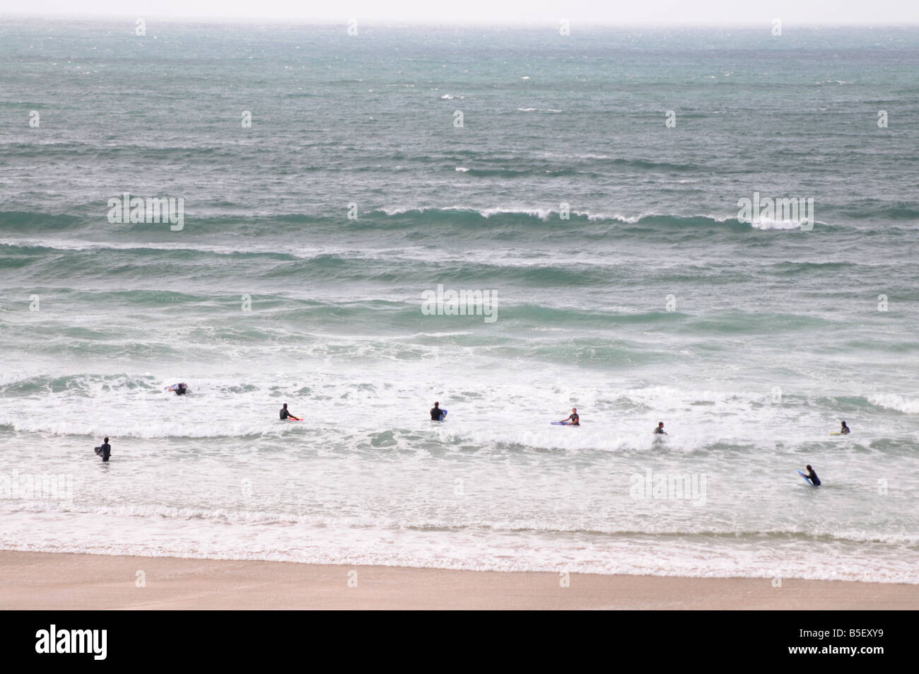 Des surfeurs de la plage à St Ives en Cornouailles, Royaume-Uni Banque D'Images