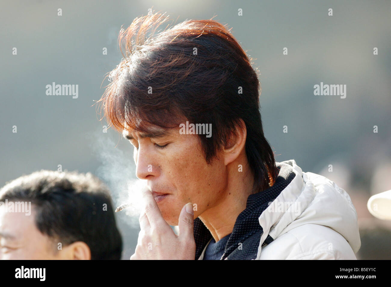 L'homme aux courses de chevaux, de fumer la cigarette, Séoul, Corée du Sud Banque D'Images
