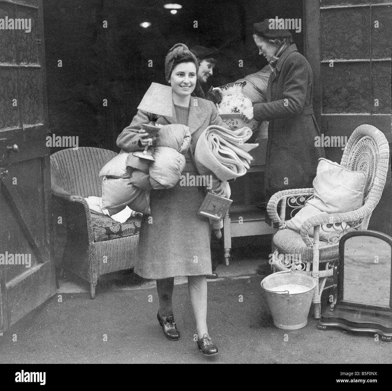 Memebrs de la Women's Voluntary Service apporte des oreillers et des couvertures pour un voisin dans une bomed hors chambre à la suite d'un raid aérien Banque D'Images