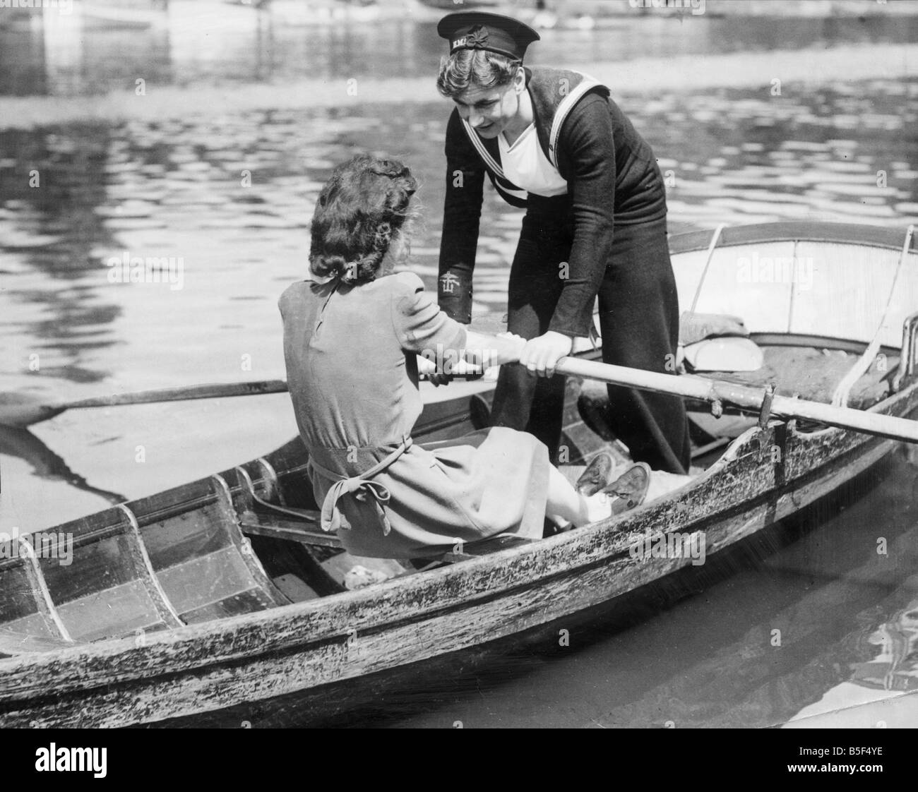Deux jeunes femmes dans un bateau à rames, un en uniforme de la Marine