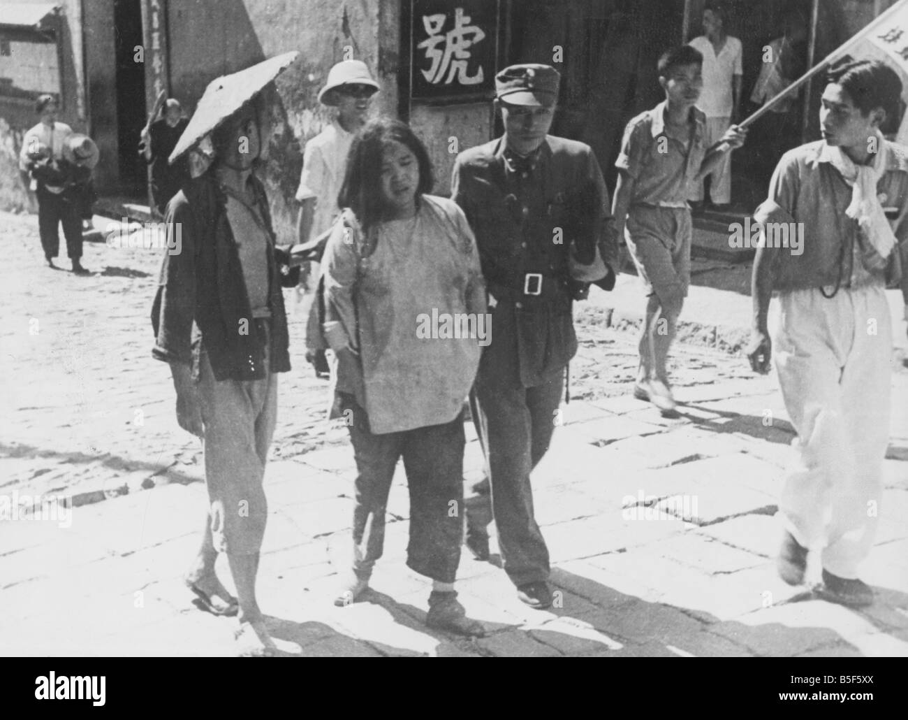 Un colonel et un coolie qui sont officiers, Riad Précaution aider une femme à partir de la scène de sa maison bombardée pendant un raid aérien japonais sur Chungking, la Chine pendant la Seconde Guerre mondiale. ;Novembre 1942 Banque D'Images