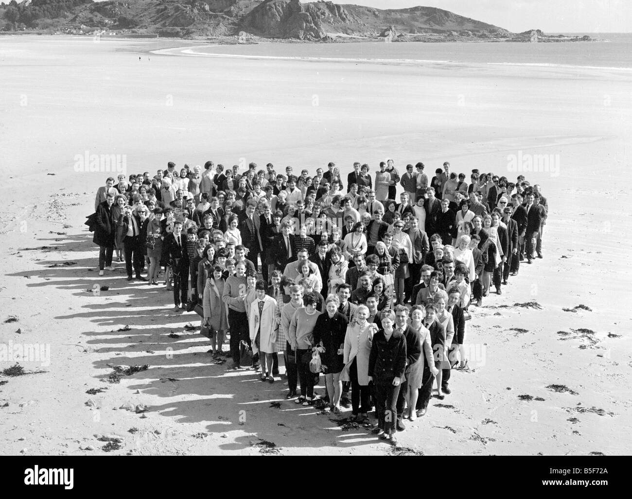 Miel sur le Sunny Isle de Jersey. 140 couples se sont réunis à St Brelades Bay pour un champagne plateau donnée par la tam Night Club. Avant de s'asseoir pour le thé qu'ils se sont réunis en forme de coeur sur le sable pour une photo souvenir. Un certain nombre de couples a leur mariage avant de battre le fisc et le changement dans les couples mariés des abattements fiscaux. Avril 1968;Y3321 ; Banque D'Images