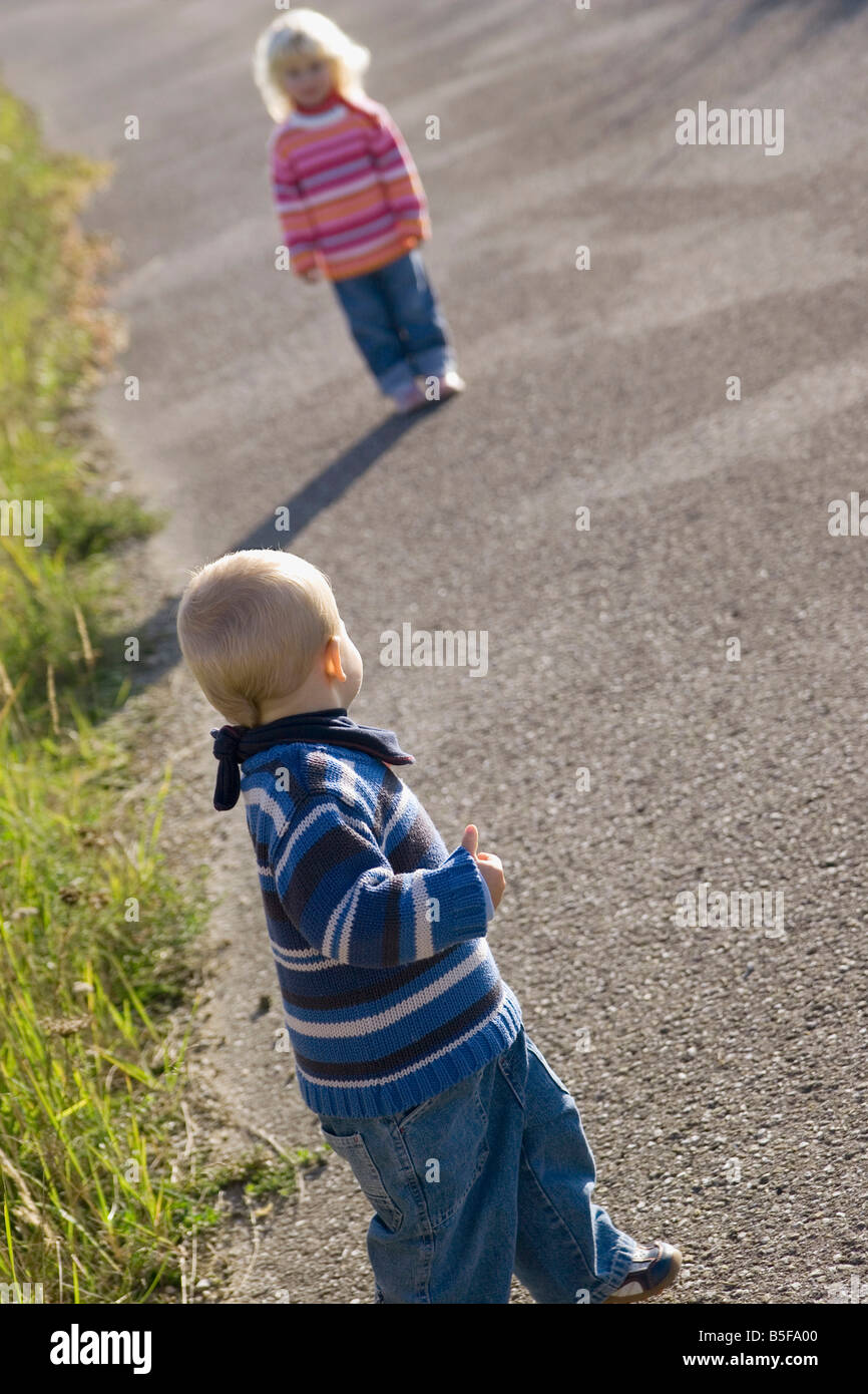 Little girl (2-3) and boy (1-2) jouant sur chemin, vue arrière Banque D'Images