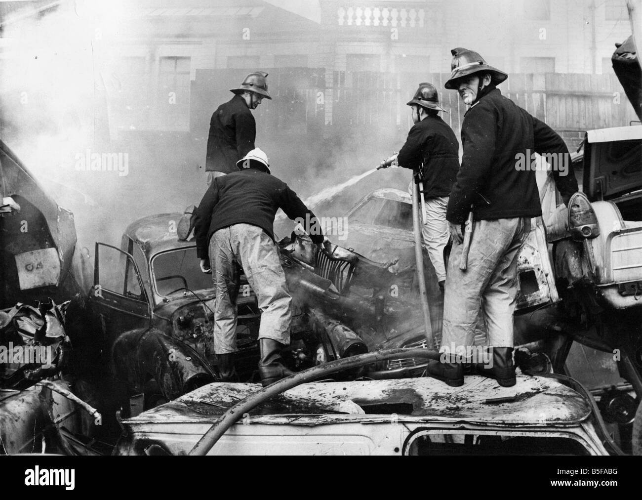 Les pompiers sur brouillés sur des piles de cartes anciennes pour lutter contre un incendie à Benfield démonteurs véhicule casse à Newcastle Banque D'Images