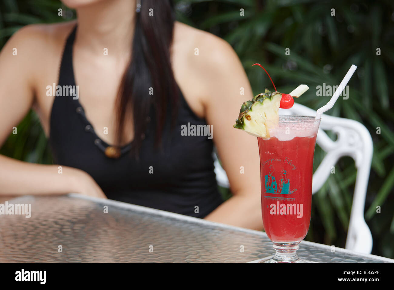 Femme avec Singapore Sling au Raffles Banque D'Images