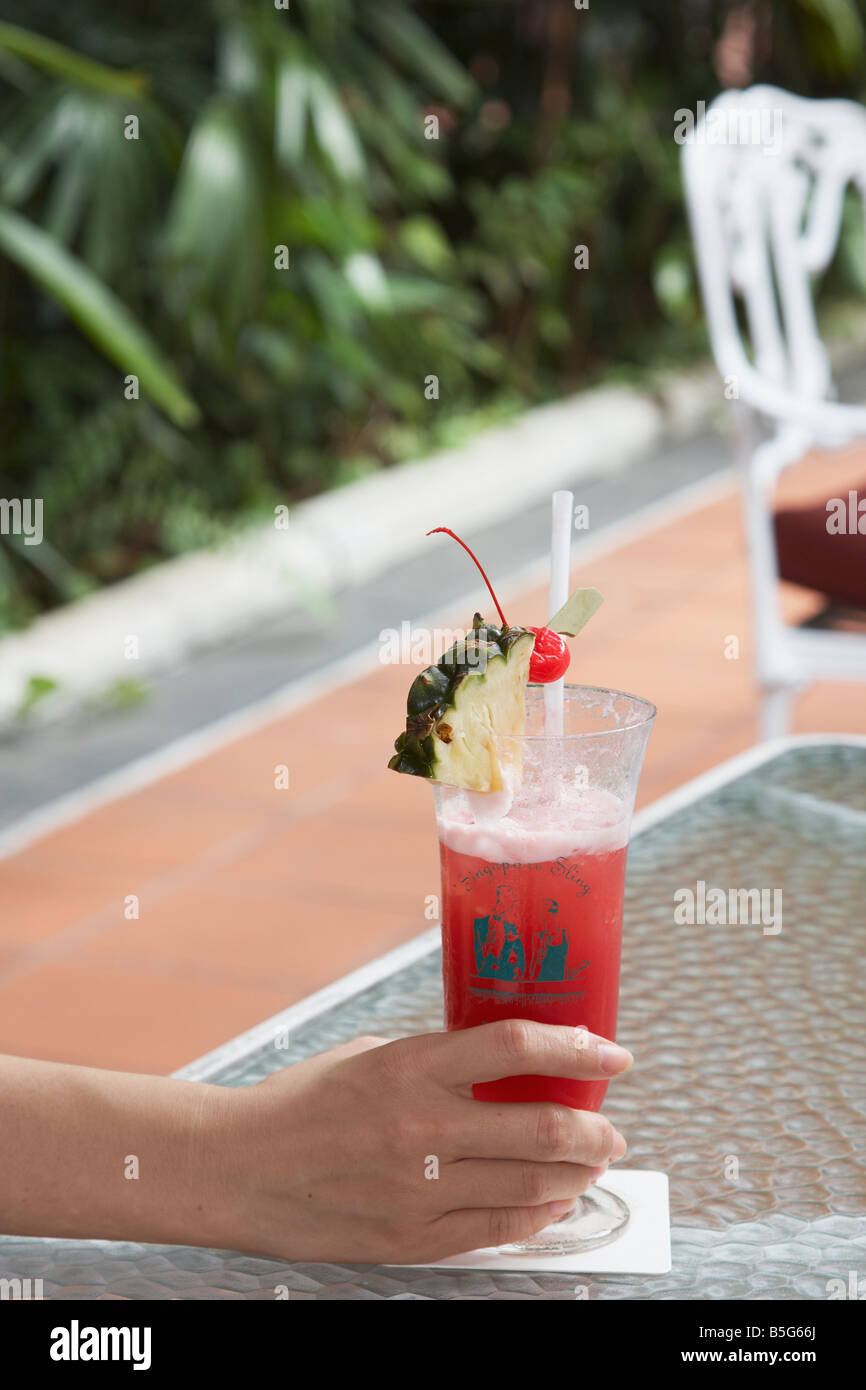 Femme avec Singapore Sling au Raffles Banque D'Images
