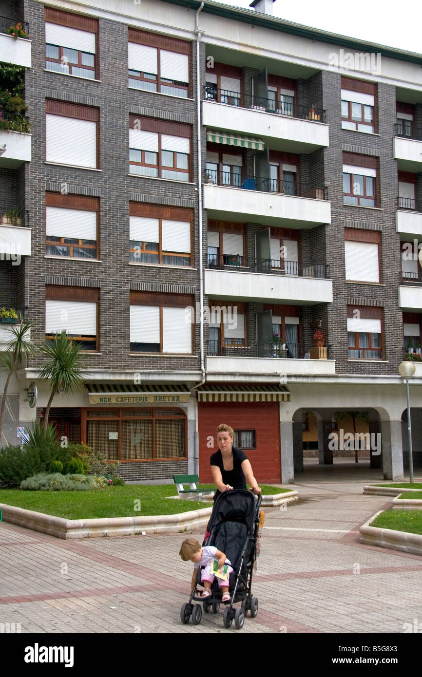Mère poussant son enfant dans une poussette en face d'un appartement à l'unité de logement dans le nord de l'Espagne Guernica Banque D'Images
