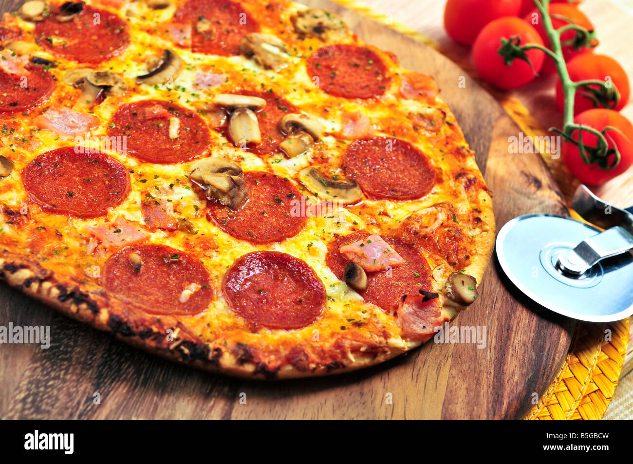 Pizza au pepperoni fraîchement cuit sur planche de bois Banque D'Images