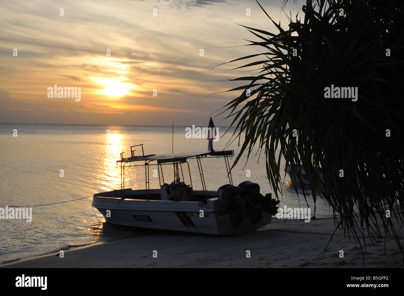 Coucher du soleil d'une plage sur Lankayan Island avec un bateau de plongée en premier plan Banque D'Images
