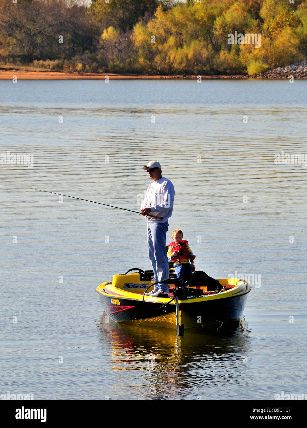 Un père de poissons sa basse bateau tandis que son petit fils montres. Arcadia lake, New York, USA. Banque D'Images
