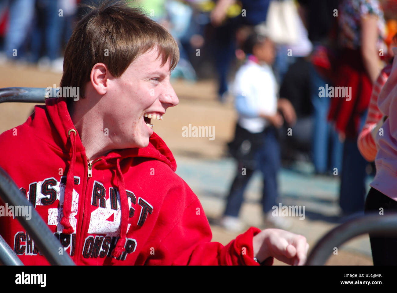 Enfant autiste s'amusant sur un manège sur une aire de jeux Banque D'Images
