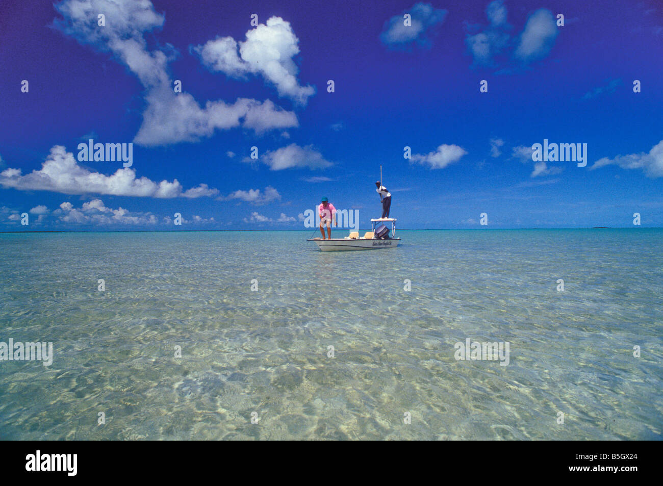 Bahamas andros island bonefishing Pêcheur et guide en eau salée peu profonde de sable clair Banque D'Images