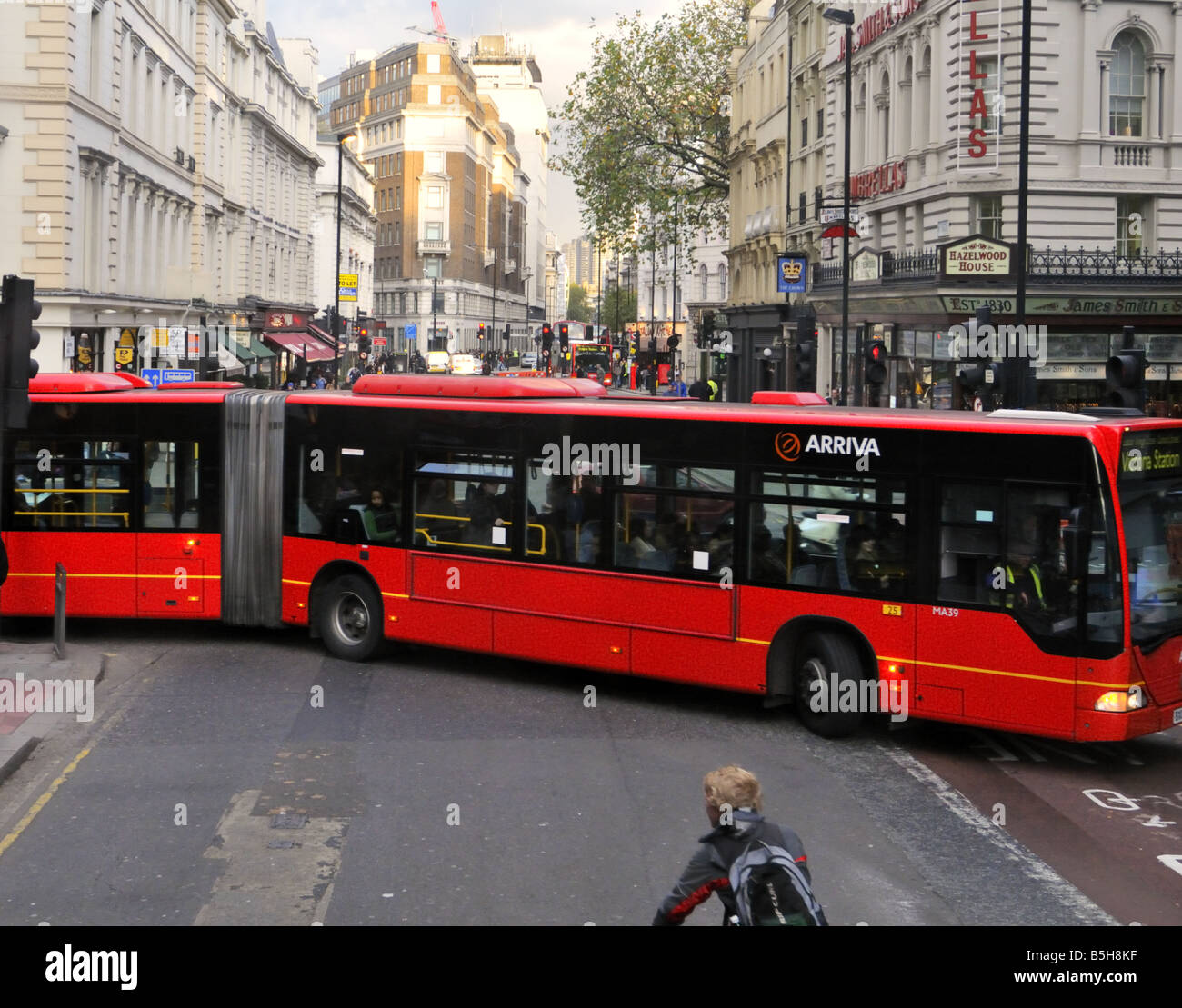 London bus rouge double longueur en tournant New Oxford Street sur un après-midi de semaine d'automne Banque D'Images