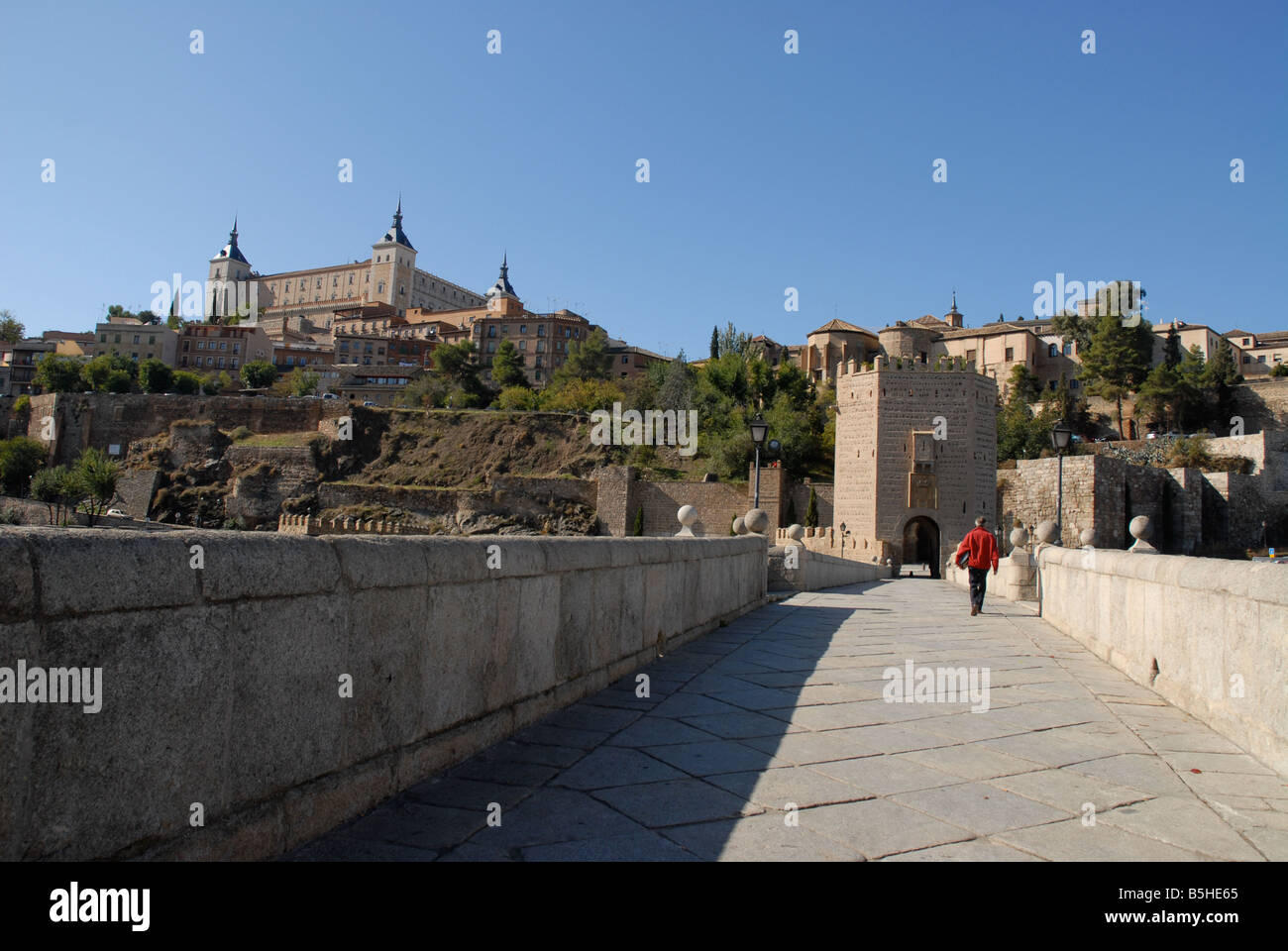 L'homme marchant sur Puente de Alcantara à ville de Tolède, Castille-La-Manche, Espagne Banque D'Images