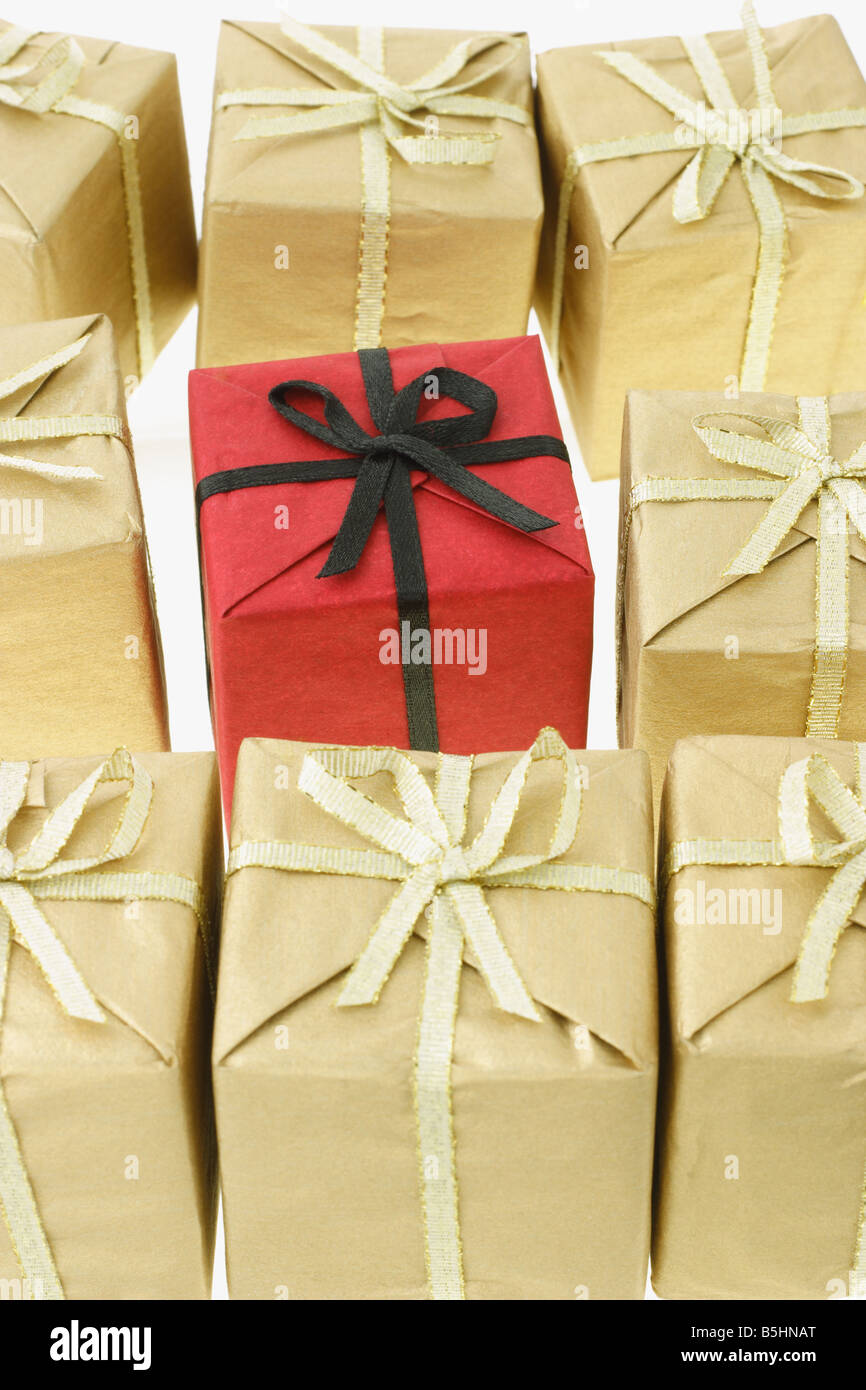 Boîte cadeau rouge autonome entouré par les boîtes marron Banque D'Images