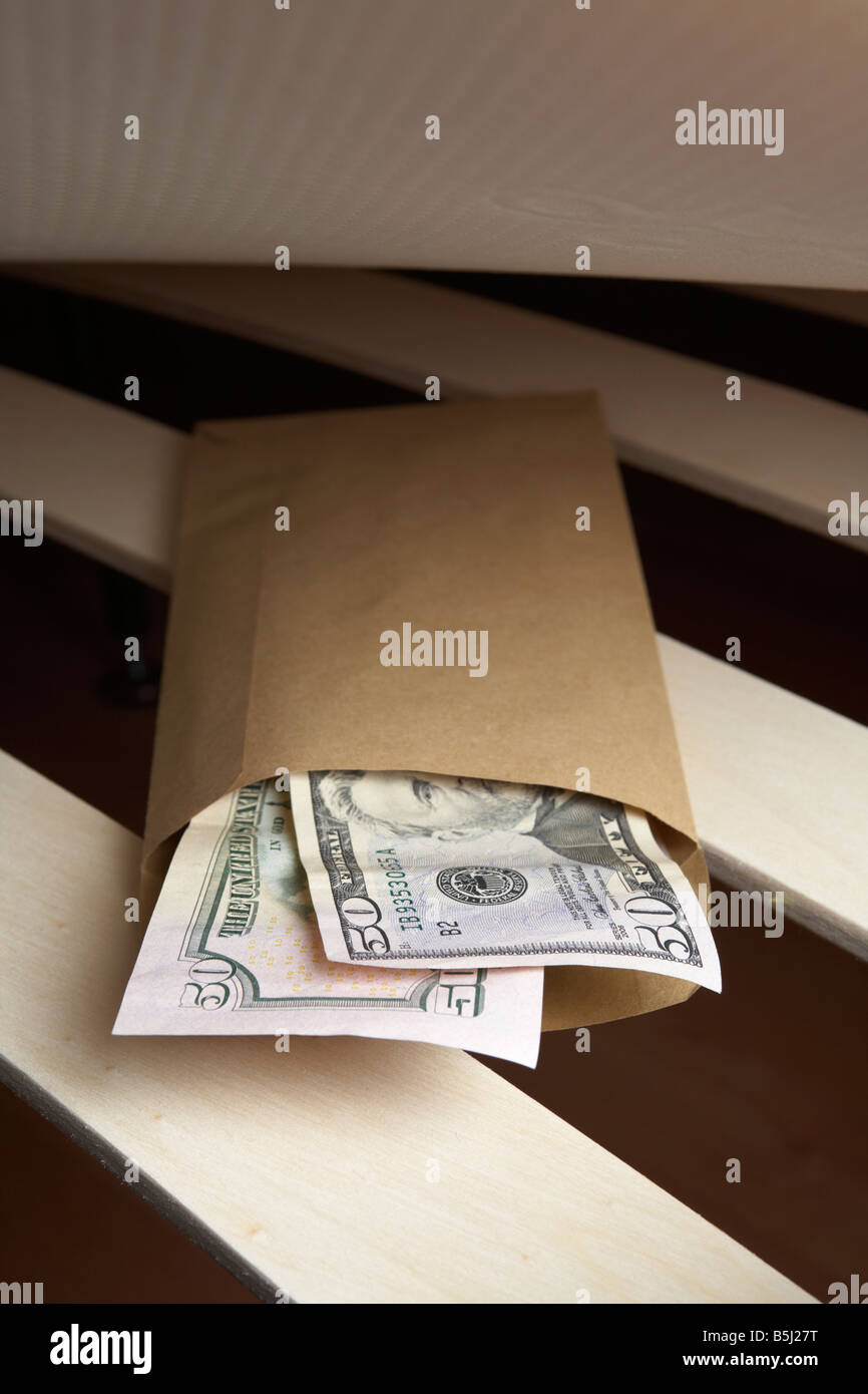 Liasse de 50 US dollars cash dans une enveloppe sous le matelas en peluche d'un lit Banque D'Images