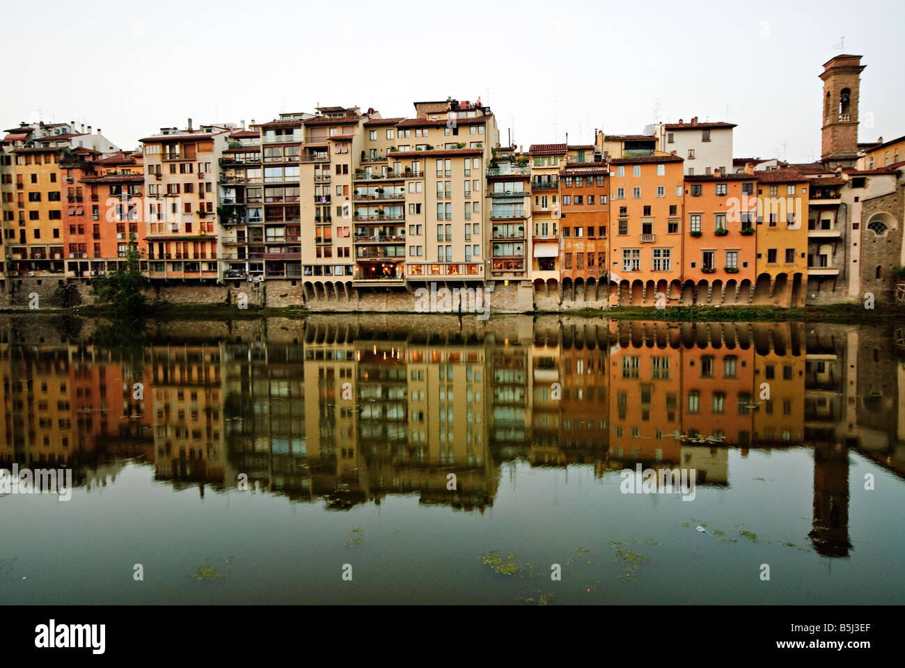 FLORENCE, Italie — L'Arno coule sereinement au cœur de Florence, ses eaux vert olive reflètent l'architecture historique de la ville. Des ponts emblématiques, dont le célèbre Ponte Vecchio, enjambent la rivière, reliant les deux moitiés de ce joyau de la Renaissance sous le chaud soleil toscan. Banque D'Images