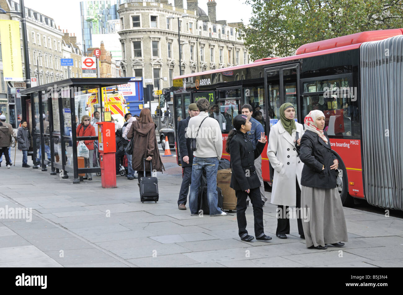 Les passagers en attente d'autobus à l'arrêt de bus devant la gare de Kings Cross Banque D'Images