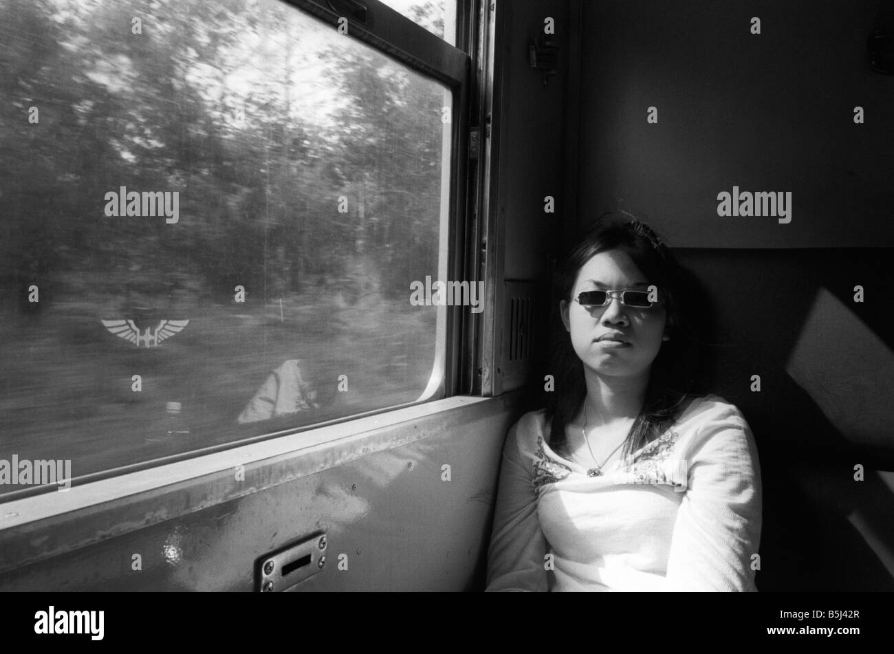 Femme thaïlandaise à lunettes assis sur un train Banque D'Images