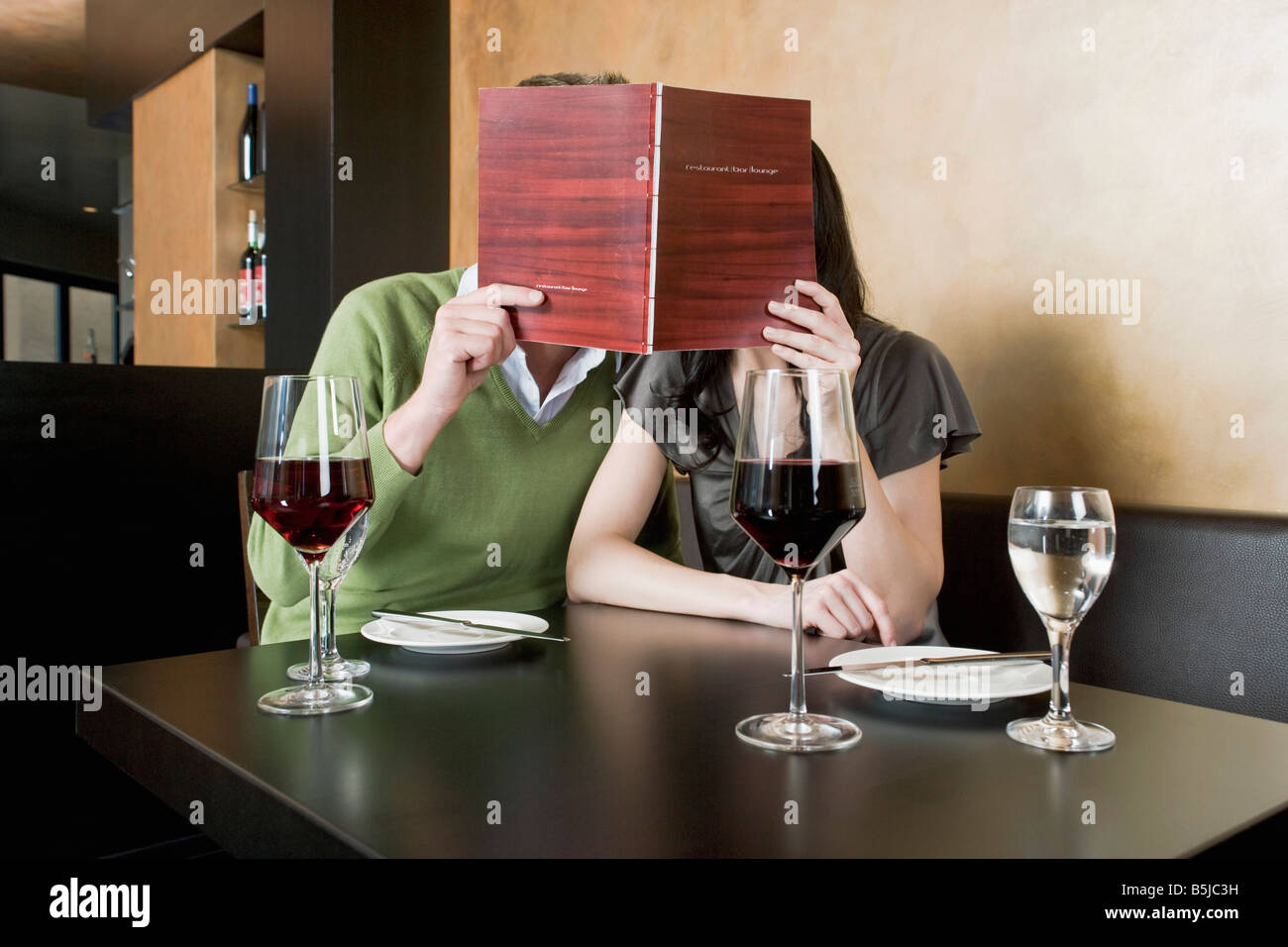 Jeune couple au restaurant menu lecture ensemble Banque D'Images