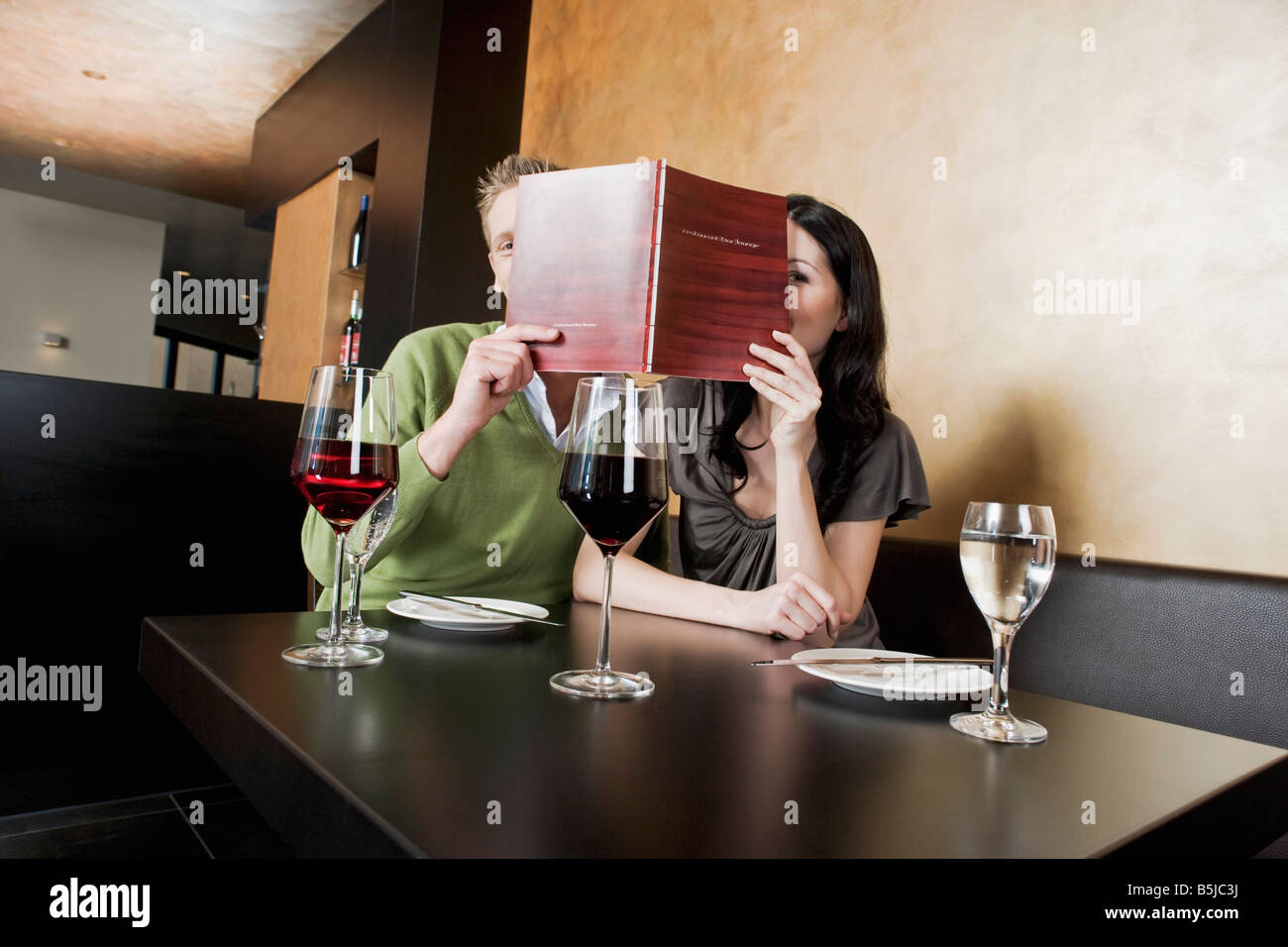 Jeune couple au restaurant menu lecture ensemble Banque D'Images