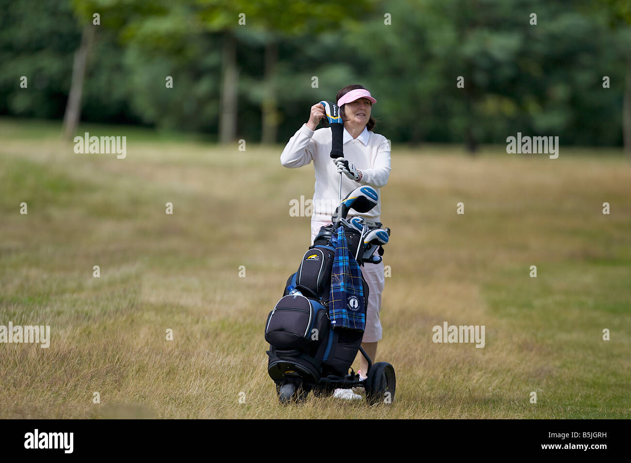 À propos de golfeur dame à jouer son coup sur un terrain de golf Banque D'Images