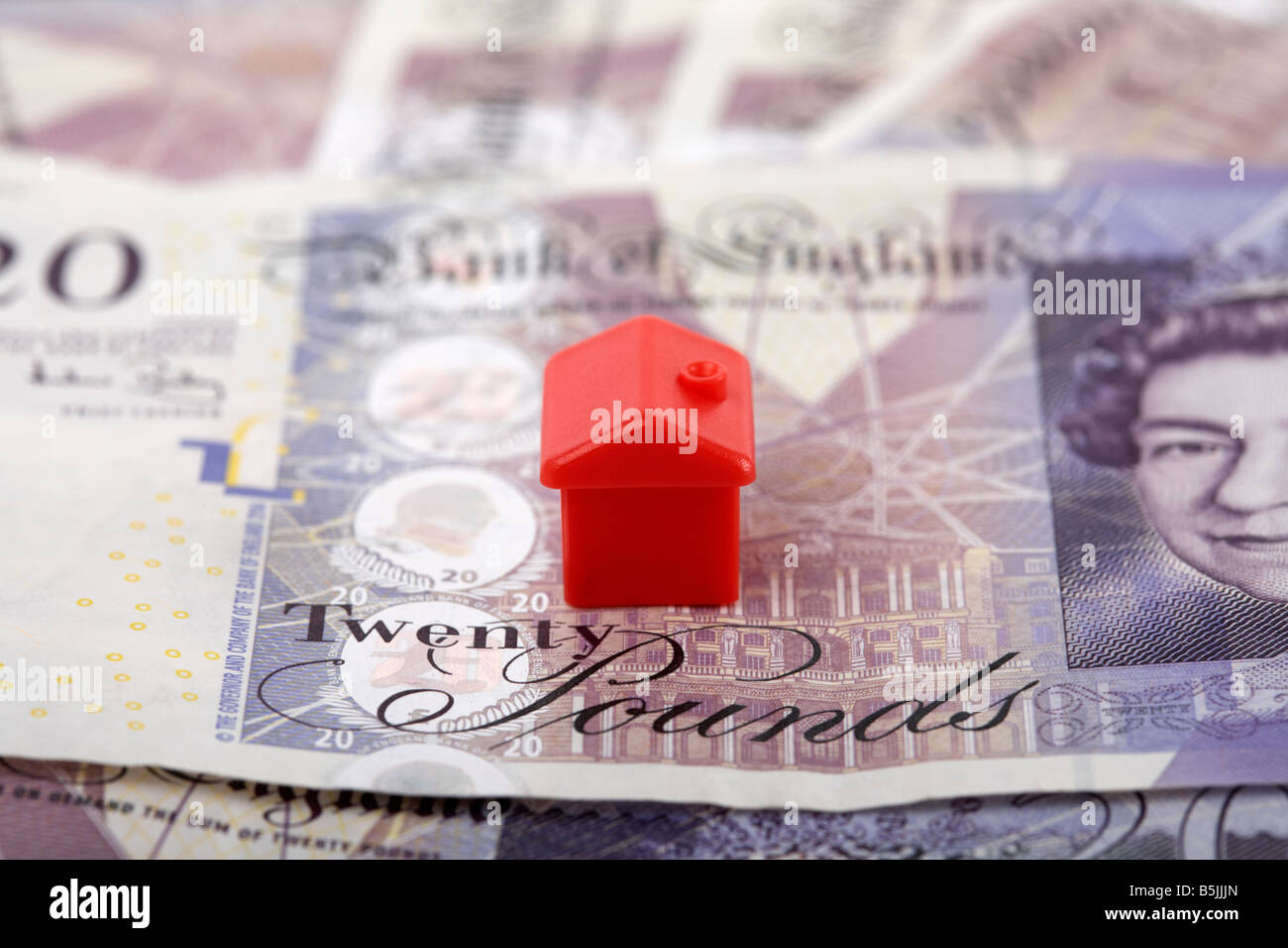 Un rouge au sommet d'une pile de 20 livres sterling en espèces de billets de banque Banque D'Images
