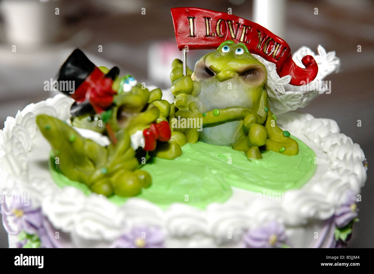 Des petites grenouilles dessus de un gâteau de mariage avec un joli message. Banque D'Images