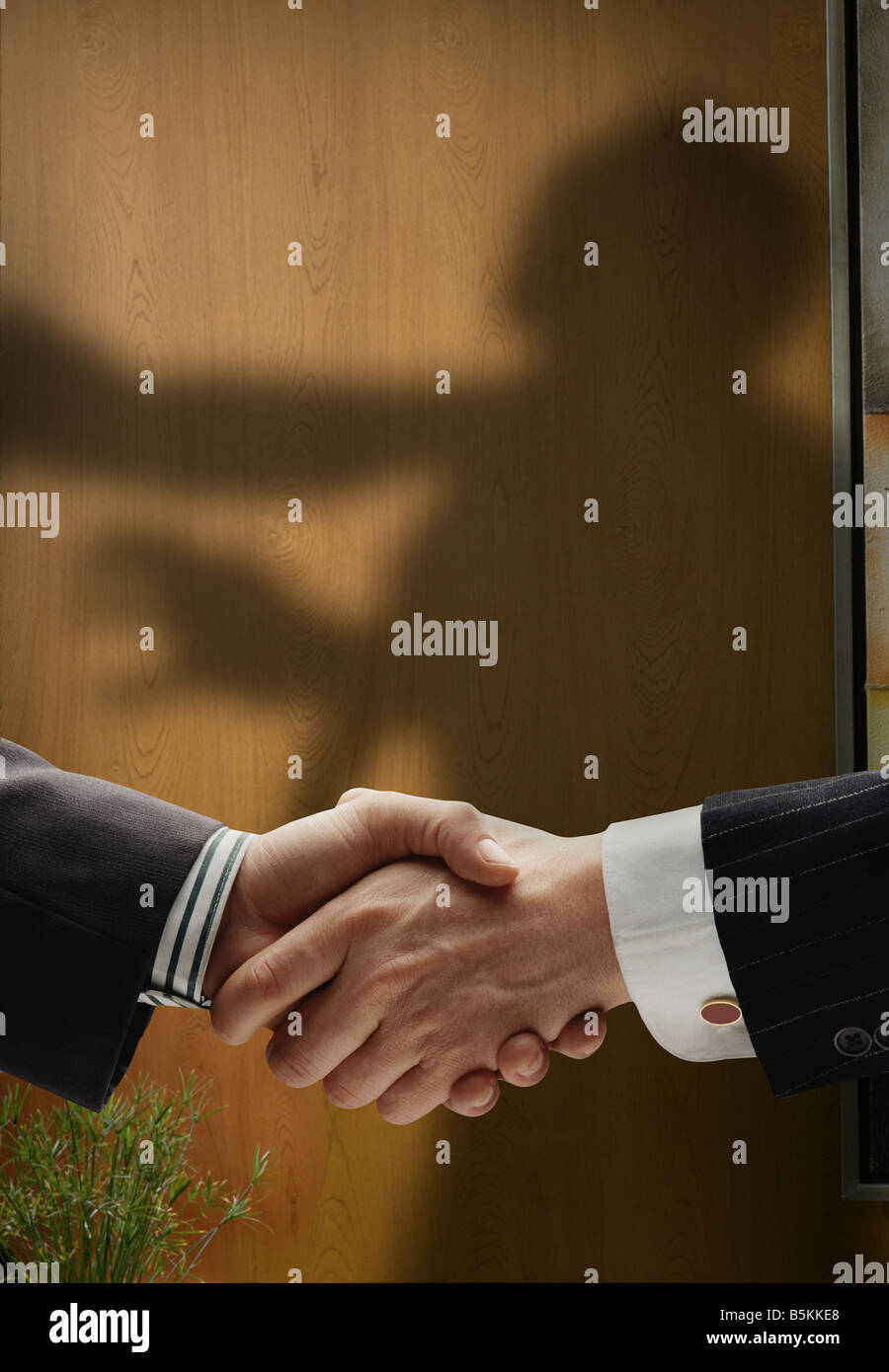 Business handshake avec ombres derrière montrant intentions réelles montrant un homme d'être pendu par le cou Banque D'Images