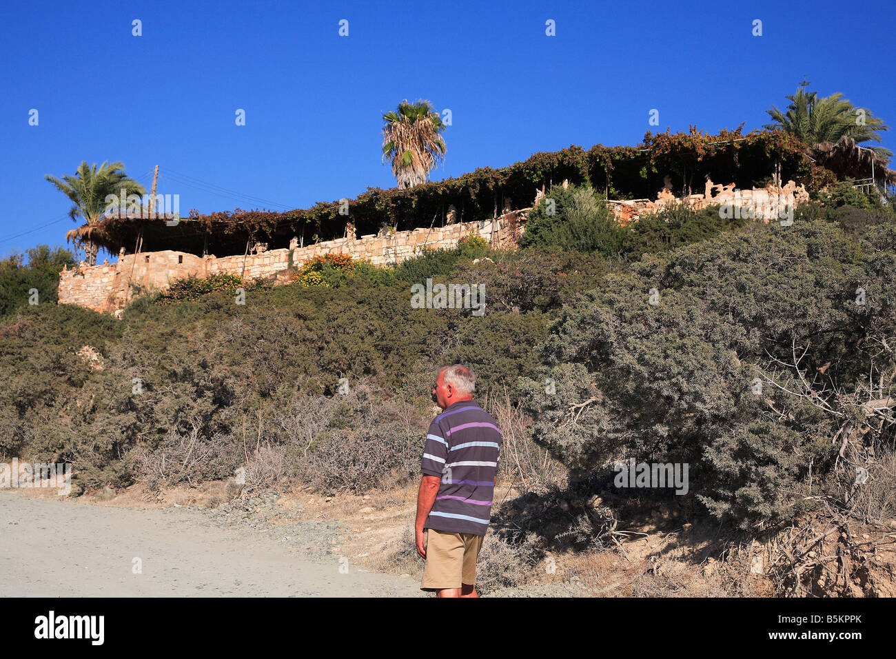 Homme plus âgé à la recherche à Viklari le dernier château Péninsule d'Akamas à ouest de Chypre Banque D'Images