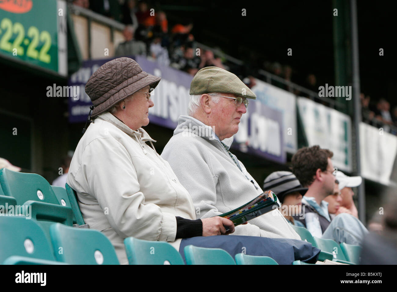 Vieux couple regarder match. wearing hat et enduire l'extérieur. Banque D'Images