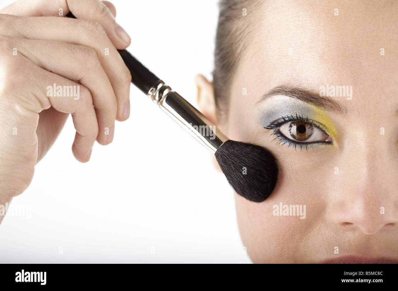 Une femme ayant appliqué avec un pinceau rouge Banque D'Images