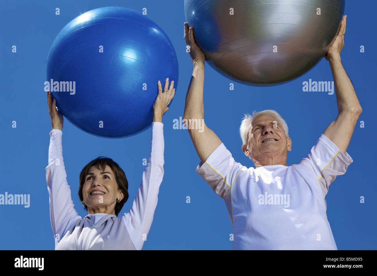 Un couple de personnes âgées holding exercise balls Banque D'Images