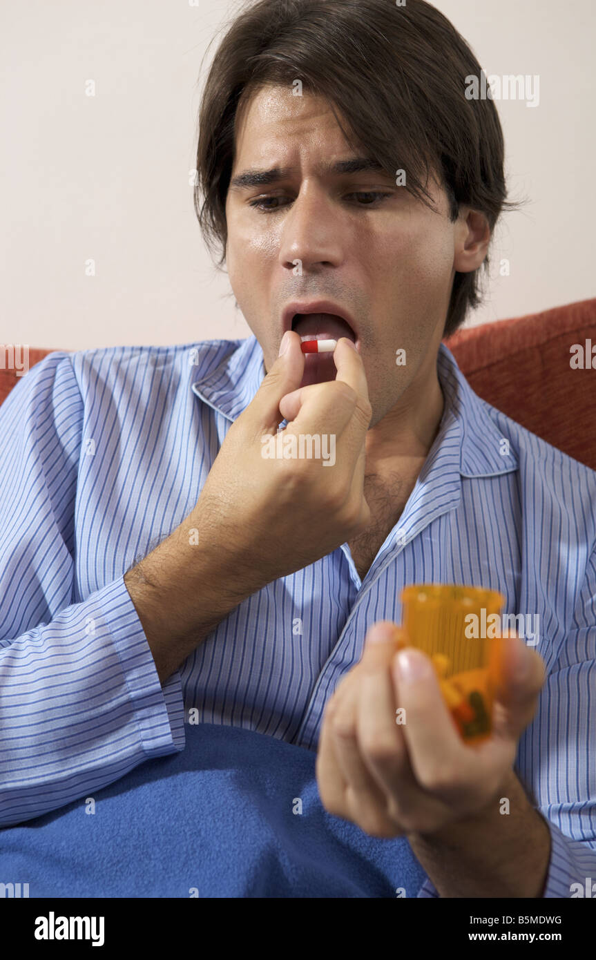 Un homme de placer un comprimé dans la bouche Banque D'Images